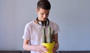 portrait-of-teenage-boy-in-headphones-holding-pot-2021-12-14-20-21-48-utc